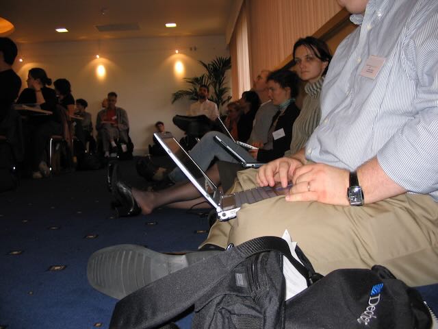 Several people with laptops sitting on the floor