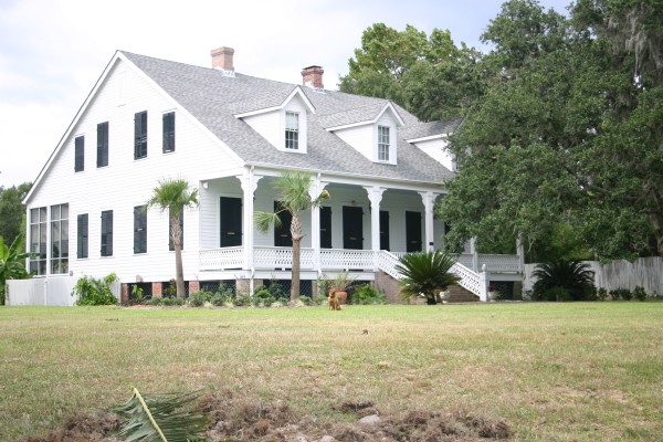 photo of a lovely white two-story house with a large yard