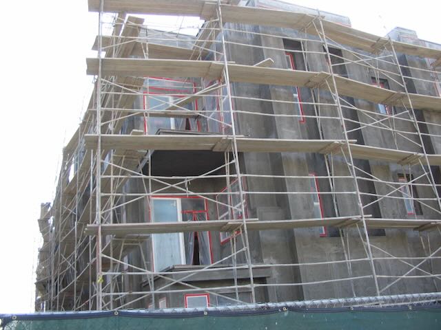 a building under construction with the beginnings of stucco applied