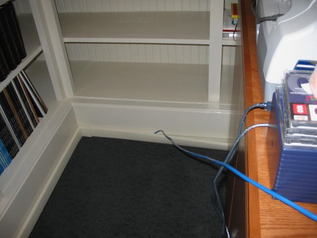 a cable emerging from a mouling and stretching toward a desk