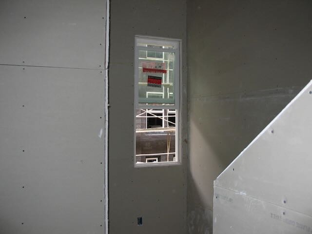 a small stairwell landing with an open window