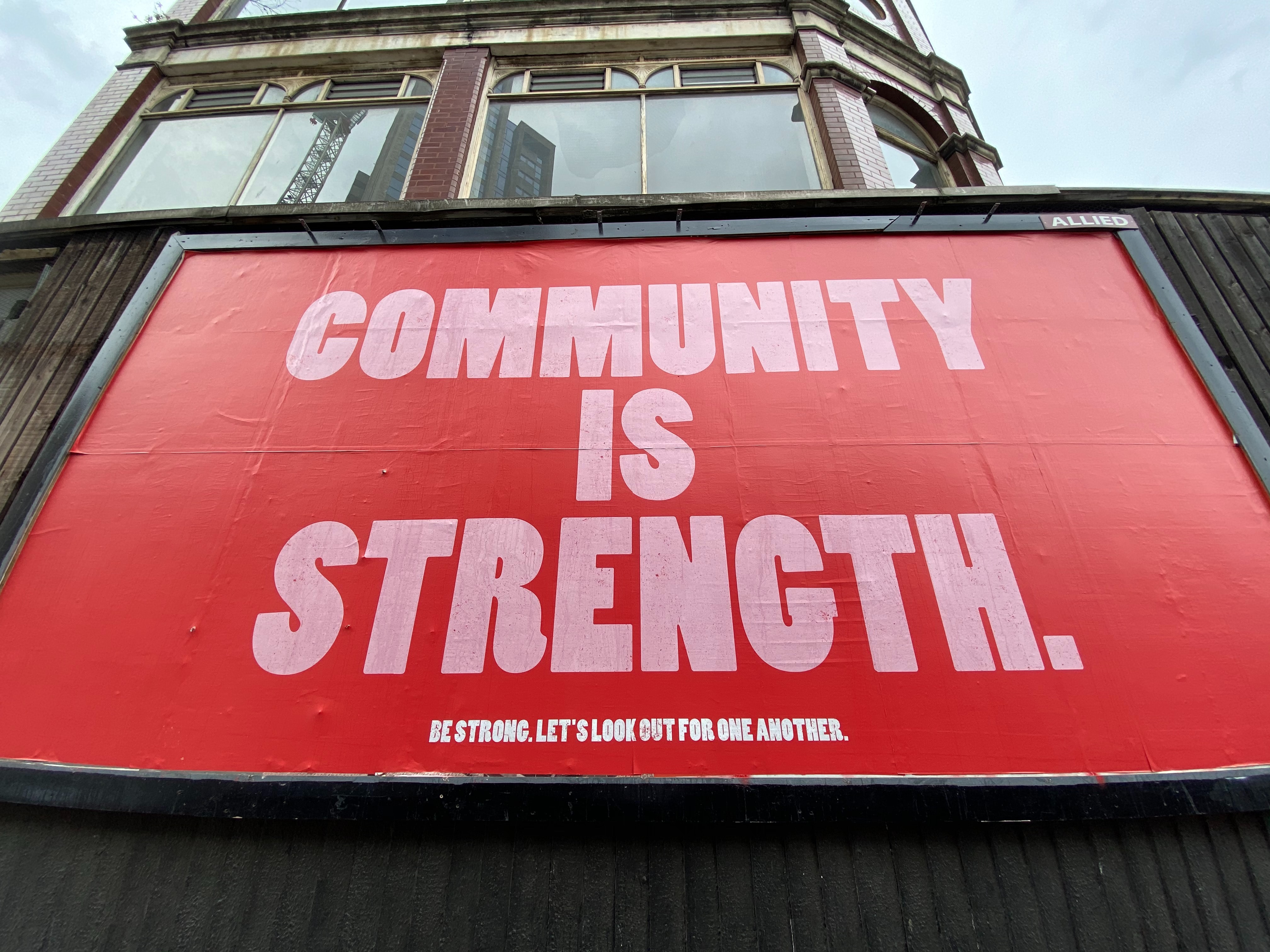 billboard reading "community is strength"